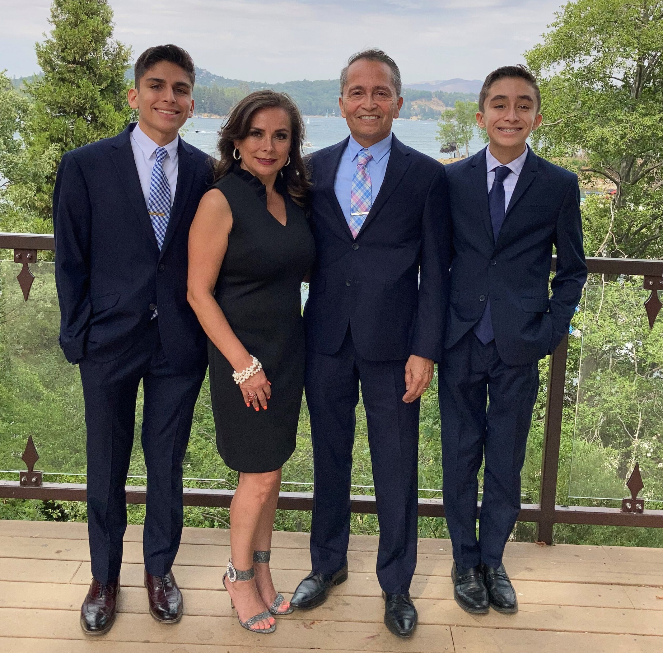The Espinosa's The Espinosa family in semi formal attire smiling in a tree line background